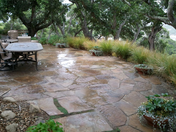 flagstone patio with surrounding shrubs and table